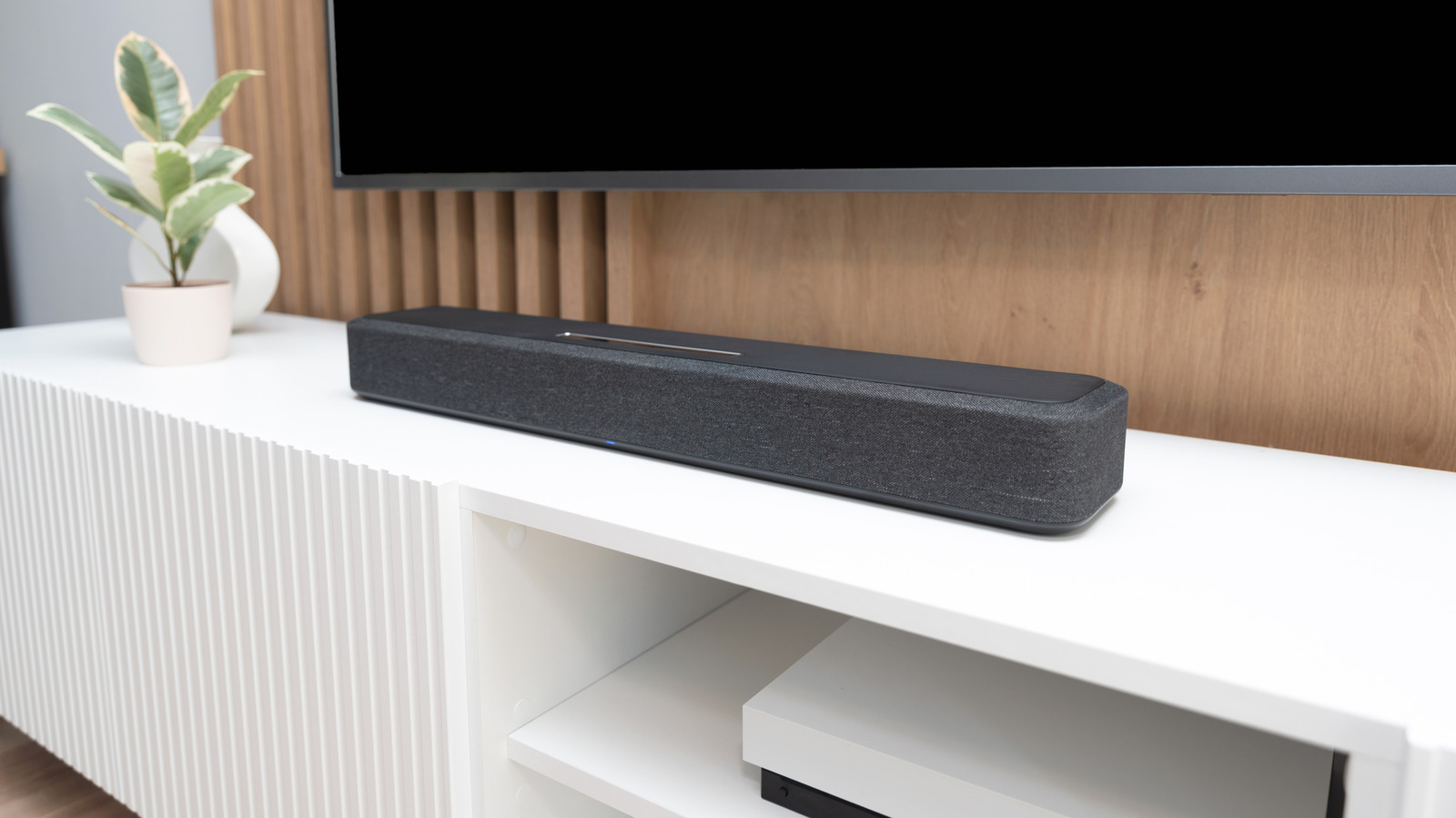 Ilustrasi instalasi soundbar modern di bawah televisi ruang hiburan keluarga