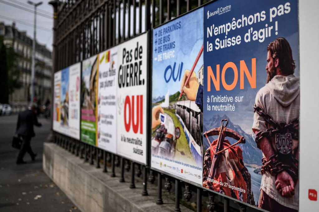 Poster kampanye referendum netralitas Swiss September 2026 di jalan kota Bern