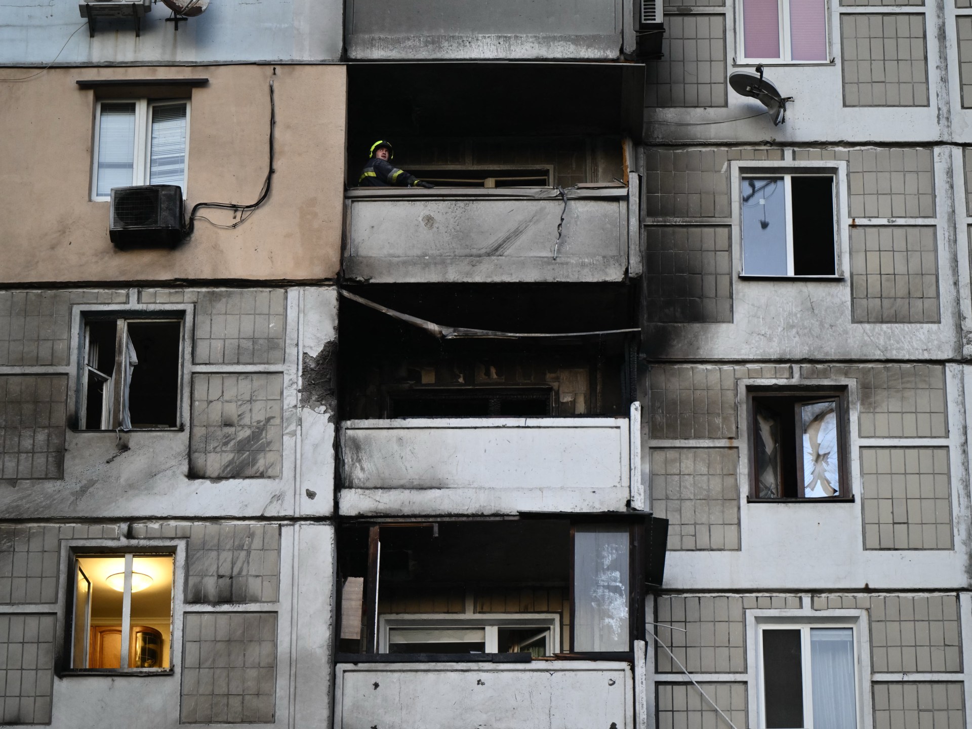 Petugas penyelamat darurat memeriksa kerusakan apartemen bertingkat akibat serangan udara di Ukraina