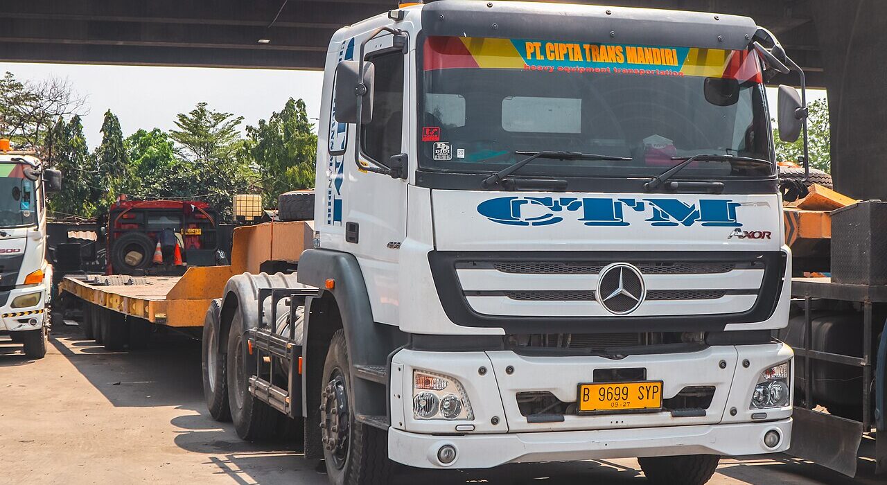 Iringan armada truk logistik muatan berat melintas di jalan raya Indonesia sebagai gambaran implementasi regulasi Zero ODOL 2027