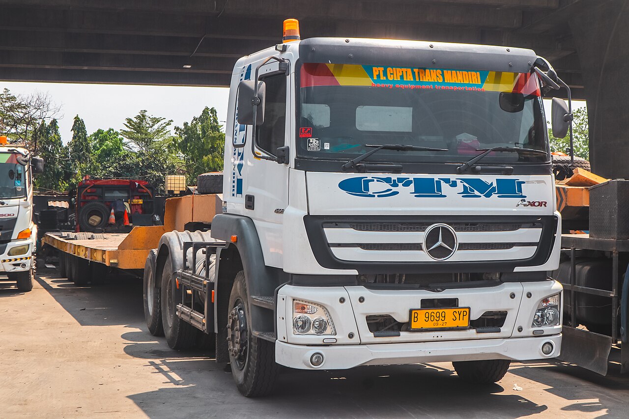 Iringan armada truk logistik muatan berat melintas di jalan raya Indonesia sebagai gambaran implementasi regulasi Zero ODOL 2027