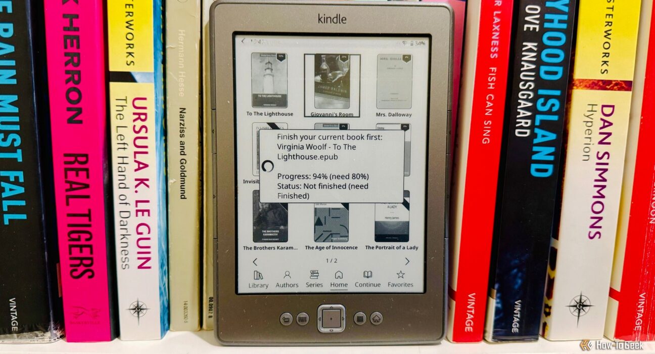 Amazon Kindle 4 menjalankan KOReader dengan notifikasi pengunci fokus baca buku di rak perpustakaan