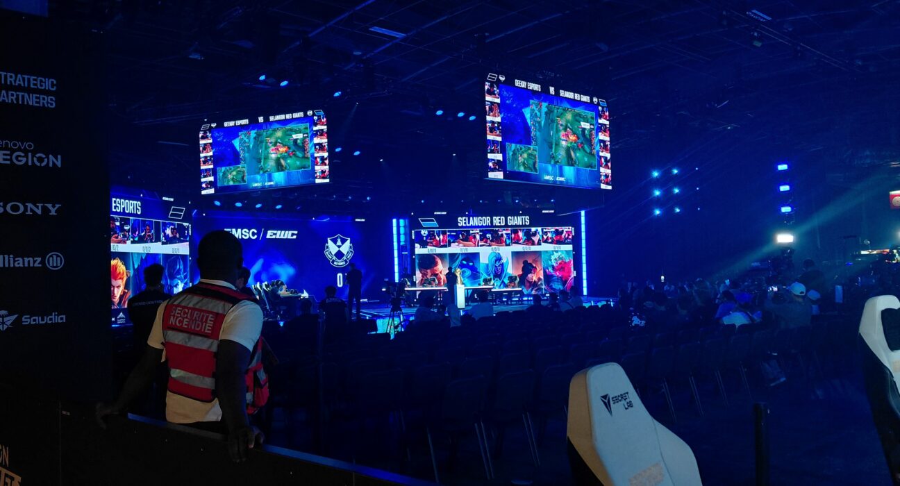 Panggung arena kejuaraan mobile esports internasional dengan atlet profesional bertanding menggunakan ponsel pintar.