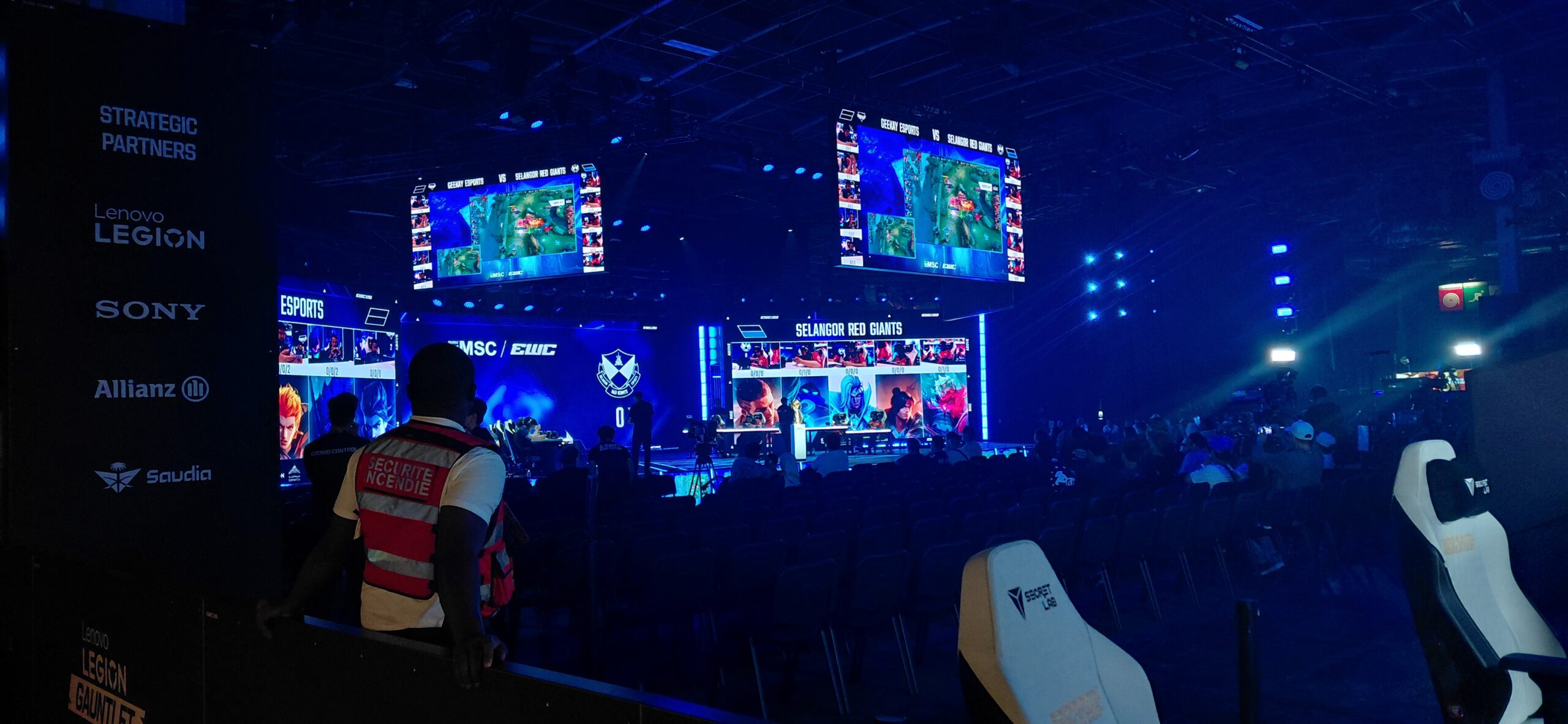 Panggung arena kejuaraan mobile esports internasional dengan atlet profesional bertanding menggunakan ponsel pintar.