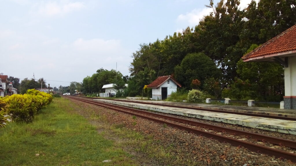Jalur infrastruktur rel kereta api memanjang melintasi lanskap terbuka Indonesia