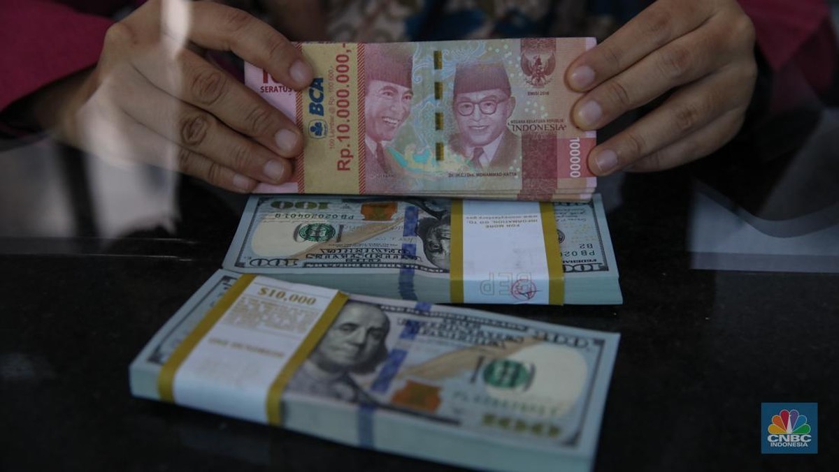 Petugas menghitung lembaran uang rupiah dan dolar Amerika Serikat di sentra valuta asing Jakarta.