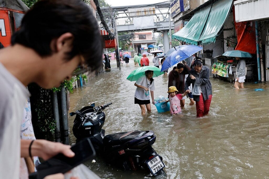 Warga Bangkok menerjang banjir di distrik Bang Bua pada 26 September 2026