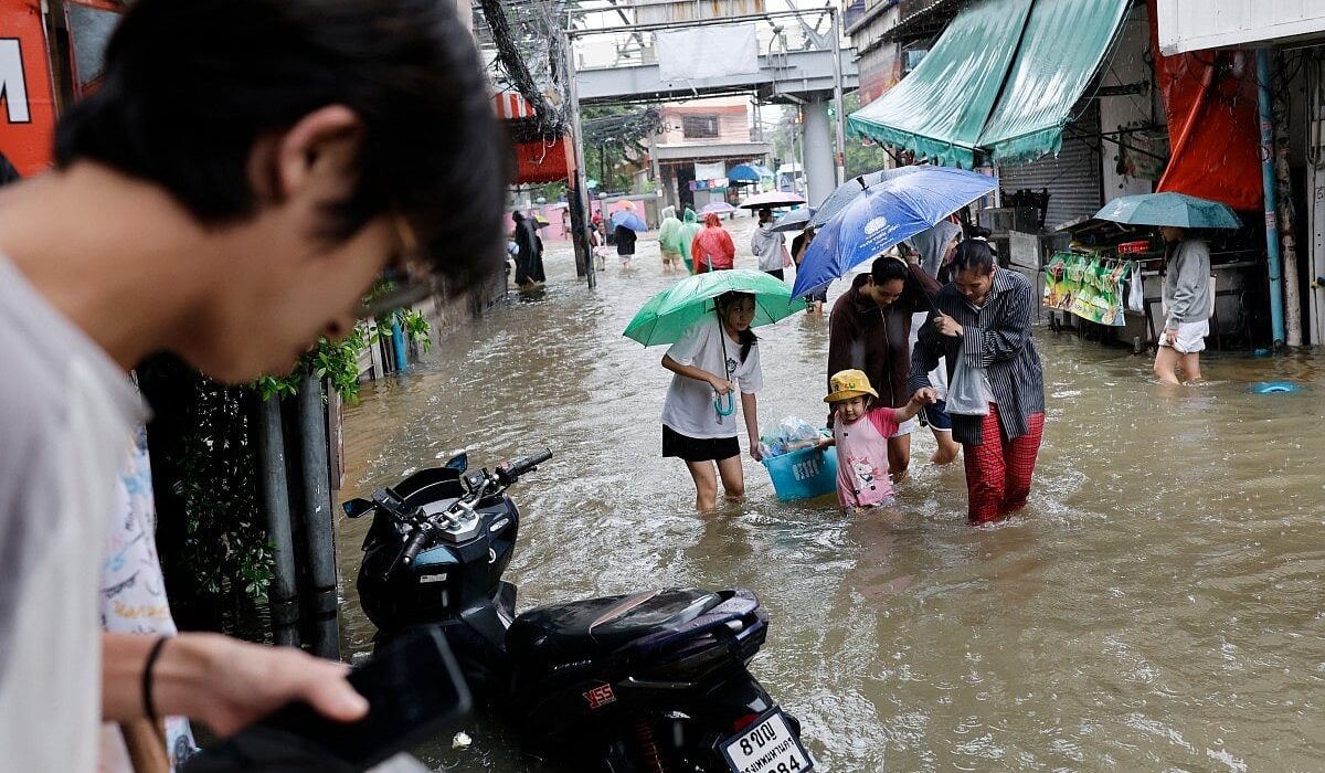 Warga Bangkok menerjang banjir di distrik Bang Bua pada 26 September 2026