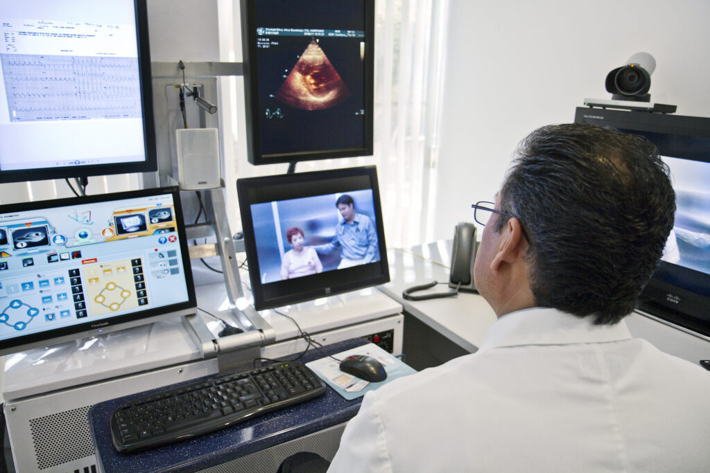 Dokter melakukan konsultasi telemedisin di depan layar komputer