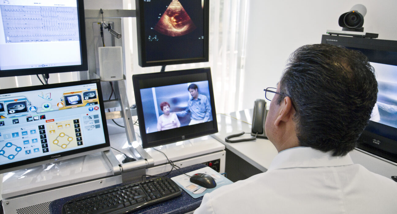 Dokter melakukan konsultasi telemedisin di depan layar komputer