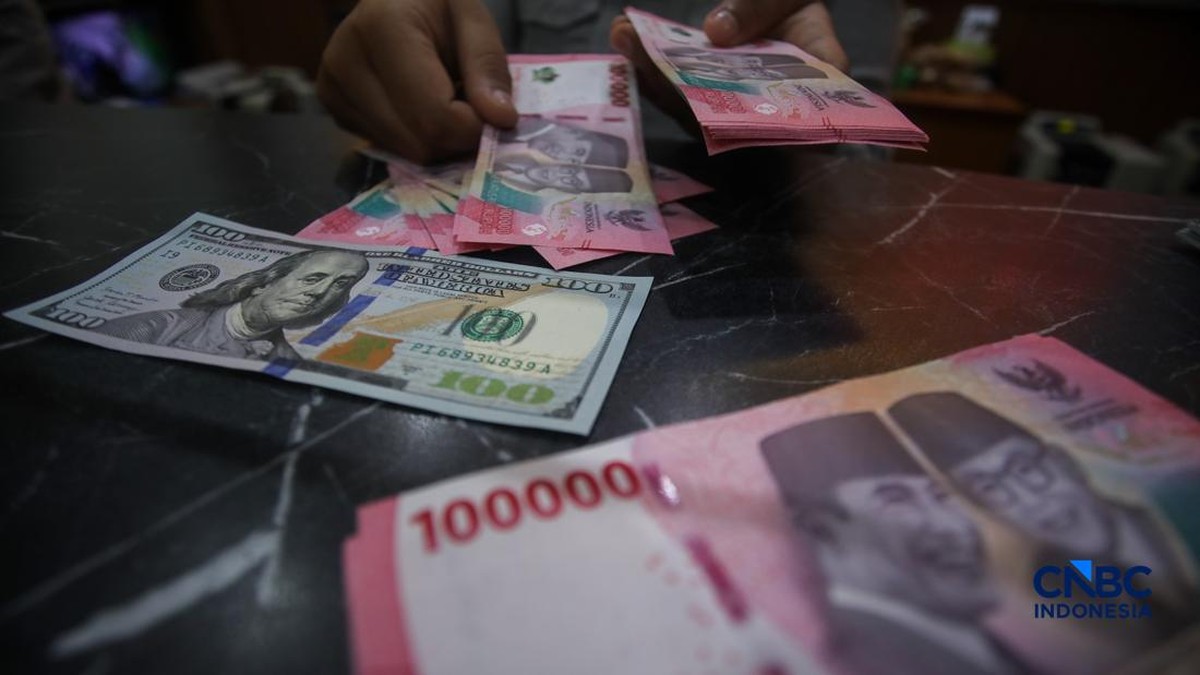 Petugas menunjukkan uang pecahan dolar Amerika Serikat dan rupiah di Dolar Asia Money Changer Jakarta