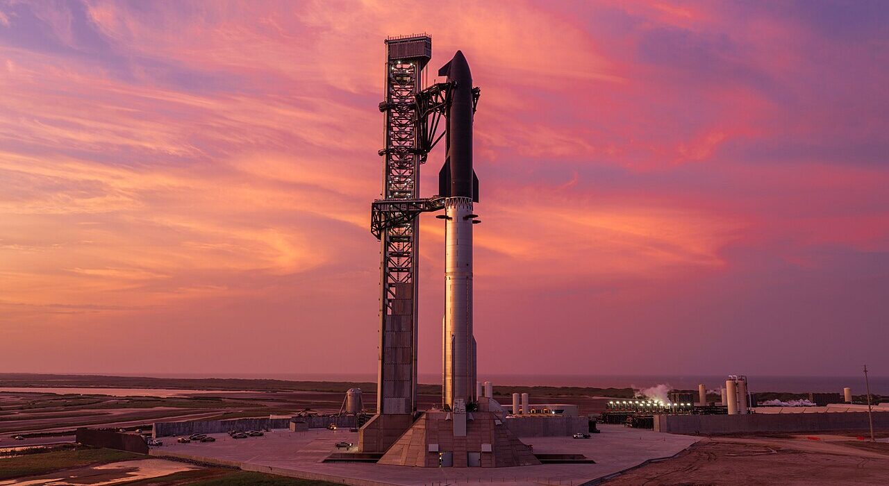 Roket SpaceX Starship berdiri di landasan peluncuran saat matahari terbenam