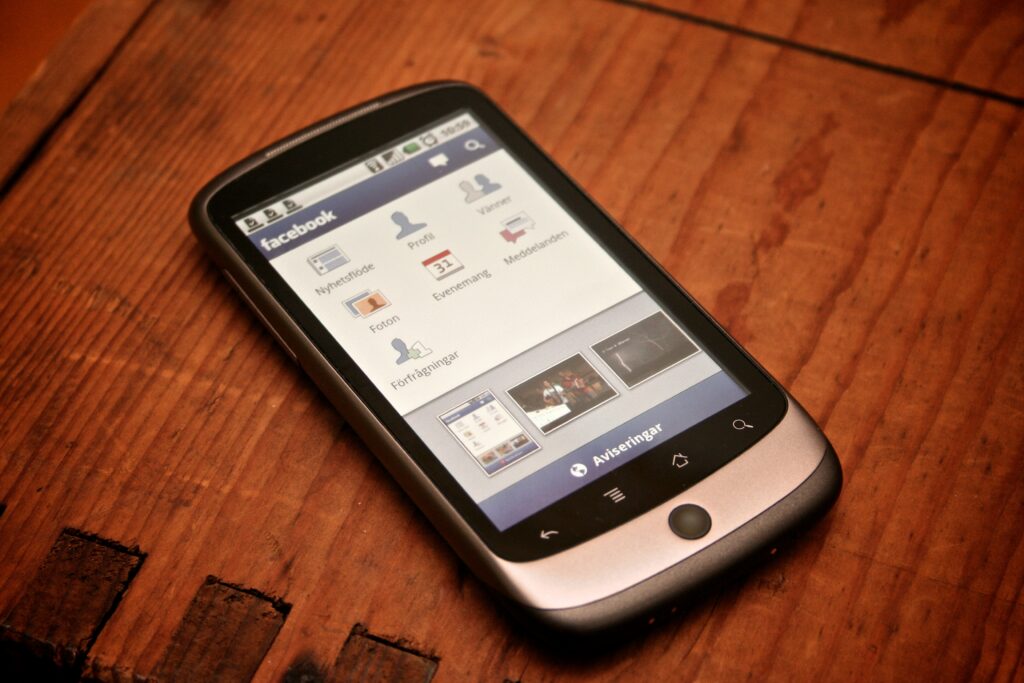 Pengguna mengakses aplikasi Facebook di layar smartphone