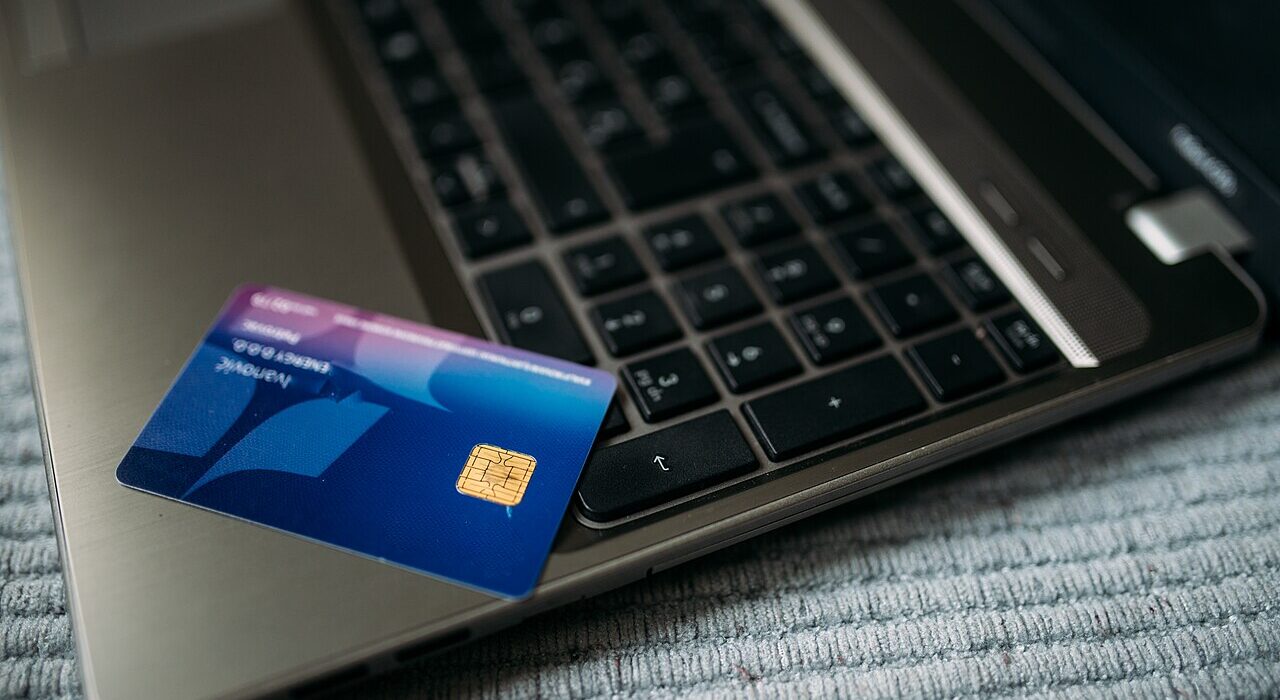 Kartu perbankan di atas laptop untuk transaksi pembayaran digital dan freelance payment gateway