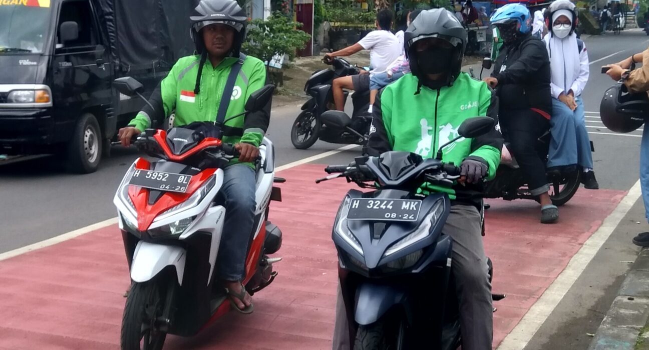 Pengemudi ojek online dan kurir logistik berbasis aplikasi di jalan raya Indonesia