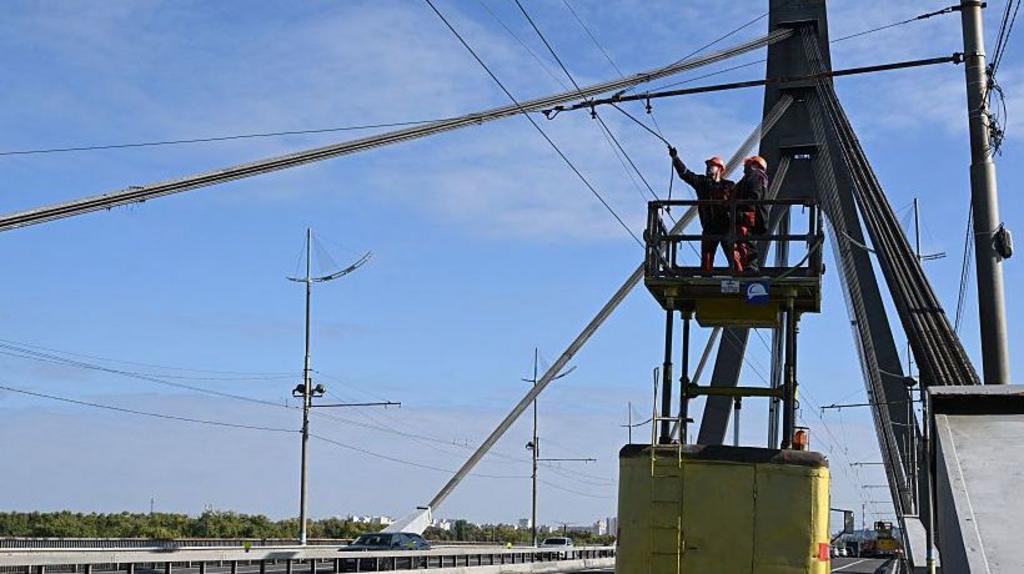 Petugas teknisi memperbaiki kabel listrik dan infrastruktur di Jembatan Pivnichnyi Kyiv pasca serangan drone Rusia Oktober 2026